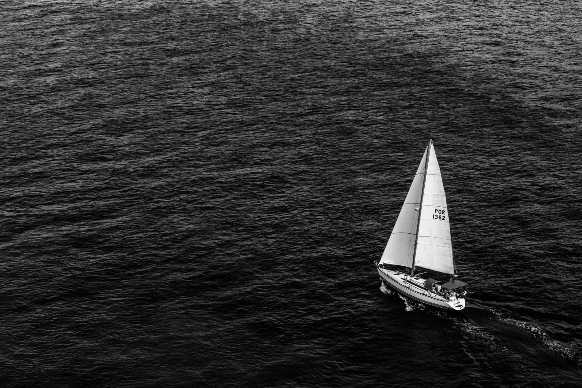 A lone sailboat crossing open water